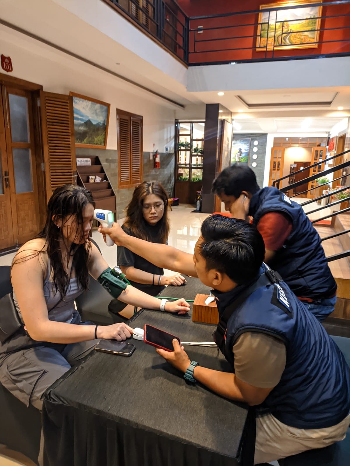 Nurse checks blood pressure during Ijen pre-ascent screening at hotel lobby